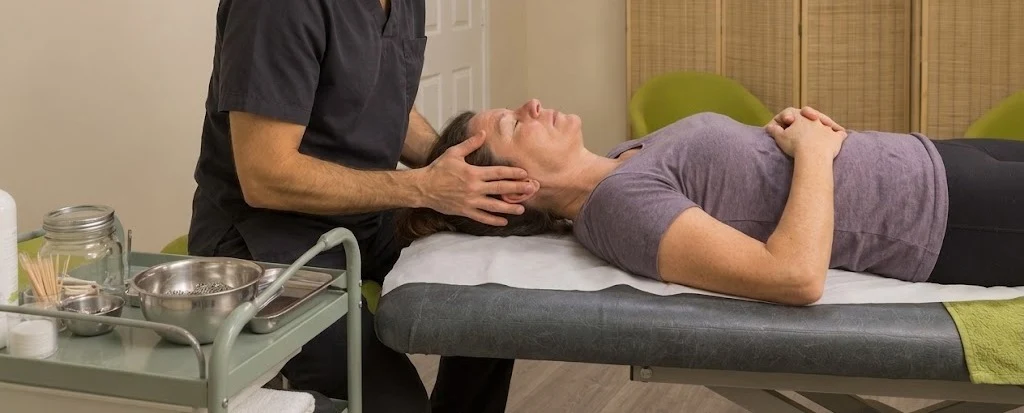 An acupuncturist's hands working on a patient's head during a treatment session