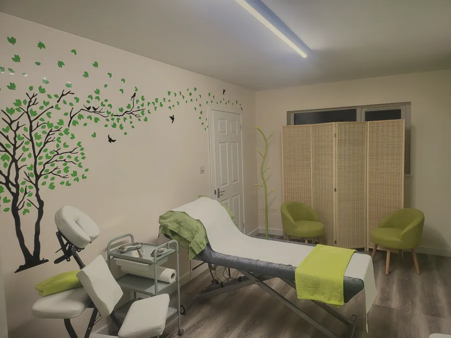 The treatment couch beneath the painted tree mural